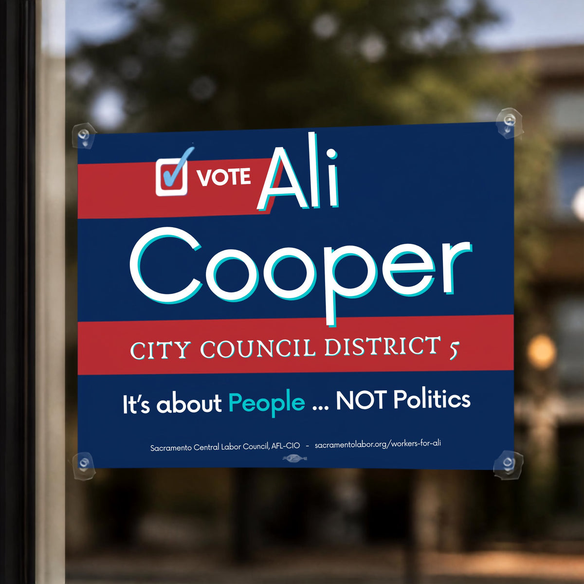 Full-bleed cardstock campaign window sign, 12x18, mounted in a storefront window